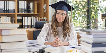 Graduate student studying with books and papers around.