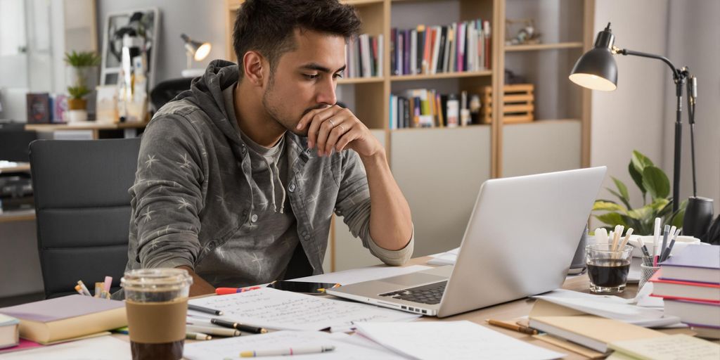 Student writing a thesis at a desk.