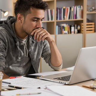 Student writing a thesis at a desk.