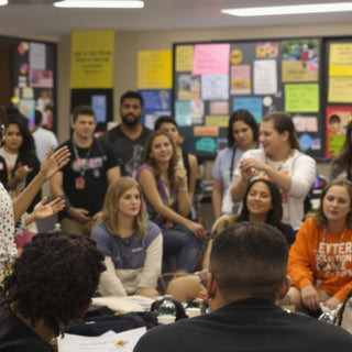 Leader speaking to an engaged audience in a bright room.