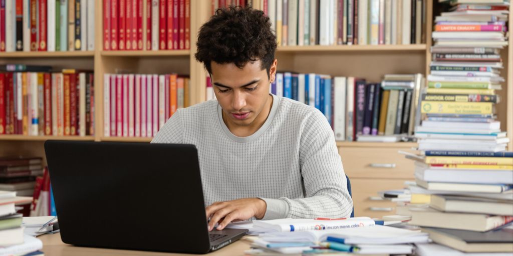 Student studying at a desk with academic materials.