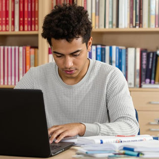 Student studying at a desk with academic materials.