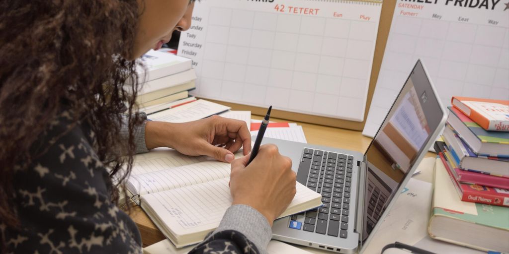 Student writing with laptop and notes, 42-day plan.