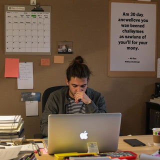 Student at desk with books and calendar for thesis writing.