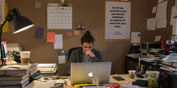 Student at desk with books and calendar for thesis writing.