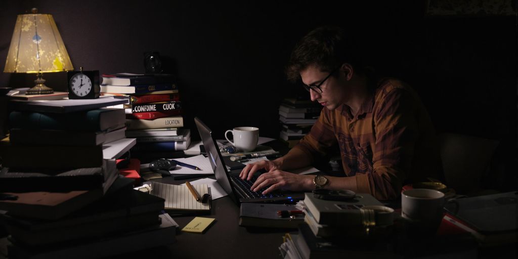 Student working late at night with coffee and books.