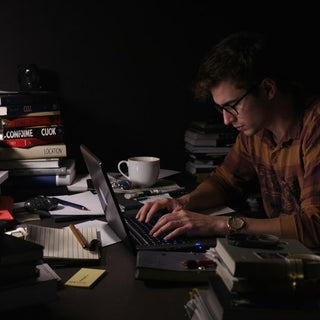 Student working late at night with coffee and books.