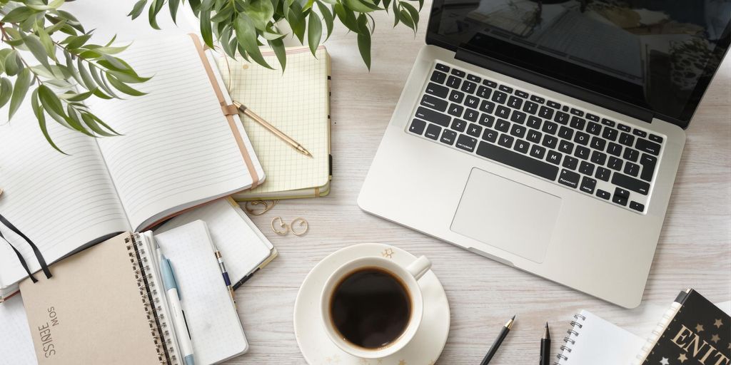 Calm workspace with laptop and coffee for thesis help.