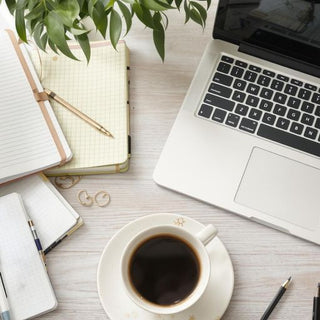 Calm workspace with laptop and coffee for thesis help.