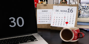 Desk with laptop, books, and a calendar.
