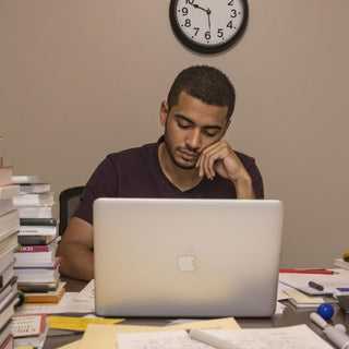 Student writing thesis in a cozy, well-lit room.