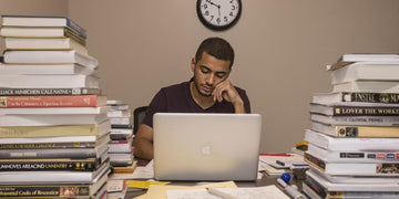 Student writing thesis in a cozy, well-lit room.